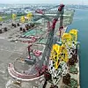 Der SK350-Ringkran mit einer Tragfähigkeit von 5.000 Tonnen hob die Jacket-Fundamente (Stahlkonstruktionen für Offshore-Windkraftanlagen) vom Deck und platzierte diese auf Betonstützen am Kai im Hafen von Taichung.