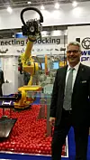 Jörg Kortmann, Gesamtvertriebsleiter bei Walther-Präzision, vor einem Fanuc-Roboter mit Werkzeugwechsler,